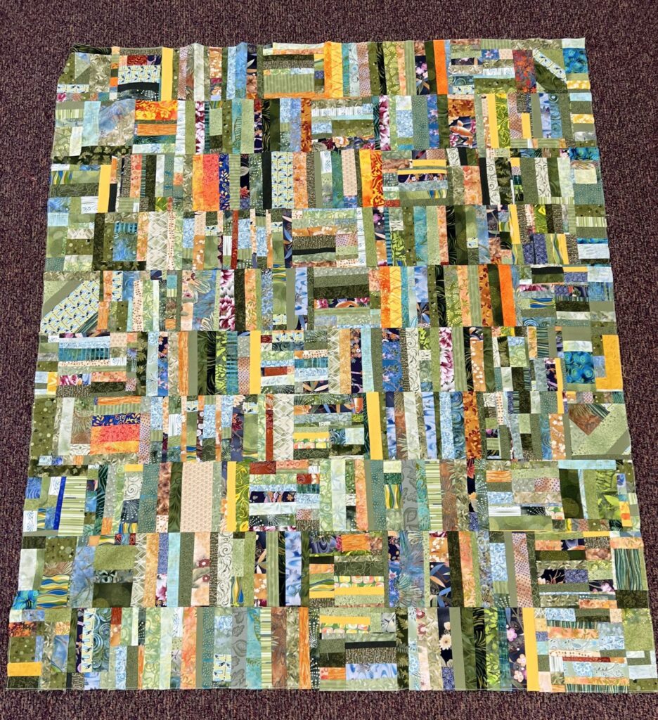 Multi colored quilt top with green and other colors