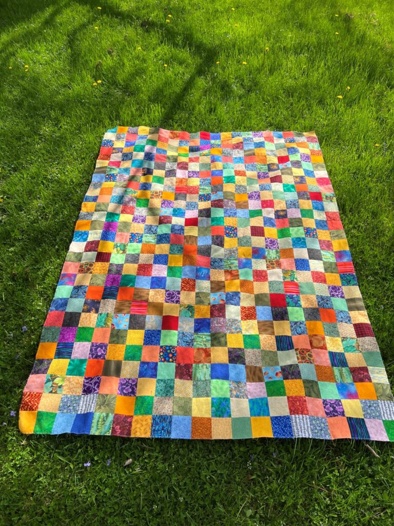 A scrappy, bright, checkerboard quilt.